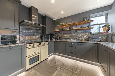 a large kitchen with gray cabinets and white appliances at The Eyrie in Keswick