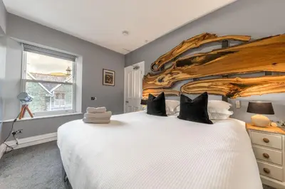 a bedroom with a large bed with a wooden headboard at The Eyrie in Keswick