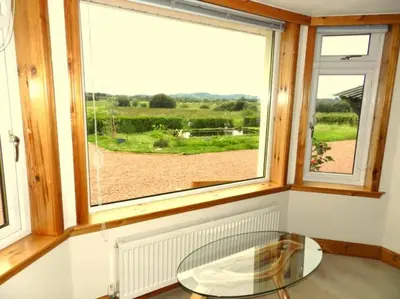 a room with a glass table and a window at Annexe Meadowbank Dumfries in Dumfries