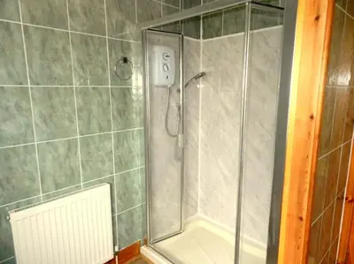 a shower with a glass door in a bathroom at Annexe Meadowbank Dumfries in Dumfries
