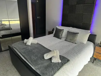 a bedroom with a large bed with towels on it at Quayside Apartment -2 Bedrooms - Sleeps 4 in Whitehaven