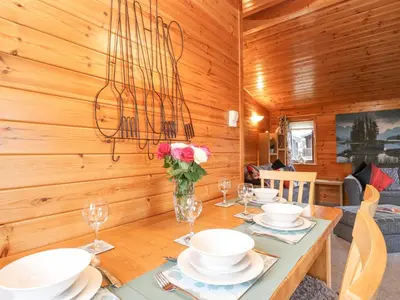 a dining room with a table with chairs and a chandelier at Hayeswater Lodge in Keswick