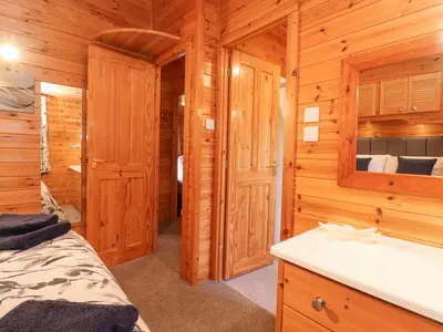 a log cabin bedroom with a bed and a sink at Hayeswater Lodge in Keswick