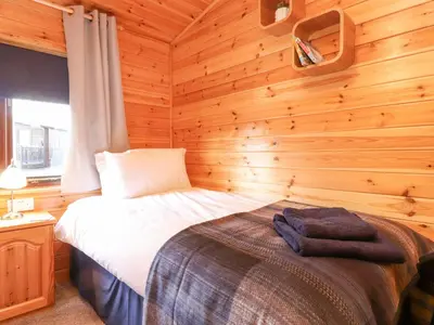 a bedroom with a bed in a log cabin at Hayeswater Lodge in Keswick