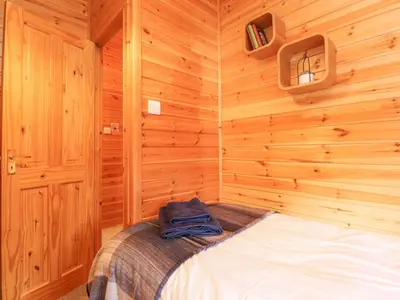 a bedroom with a bed in a wooden room at Hayeswater Lodge in Keswick