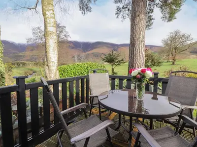 a table with a vase of flowers on a deck at Hayeswater Lodge in Keswick