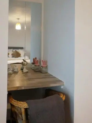 a room with a wooden table with a bed at Dumfries Apartment 2 in Dumfries