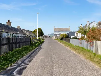 an empty street with houses and a fence at Sea View 59 - Uk45586 in Mainsriddle