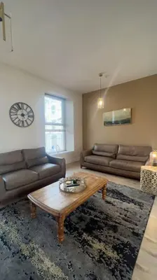 a living room with couches and a coffee table at Tynwald Apartments in Douglas