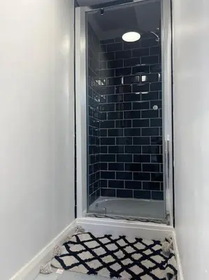 a bathroom with a shower with a glass door at Tynwald Apartments in Douglas
