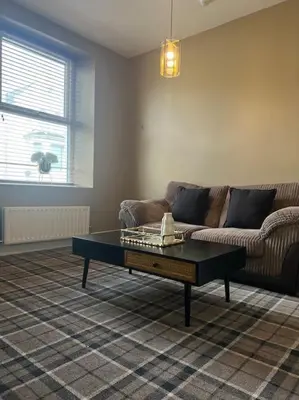 a living room with a couch and a coffee table at Tynwald Apartments in Douglas