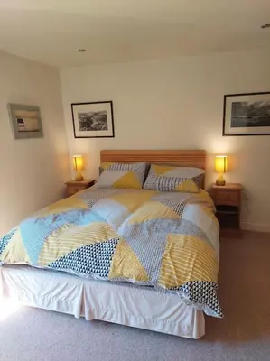 a bedroom with a bed with two lamps on two tables at North Lake District rural retreat in Penrith