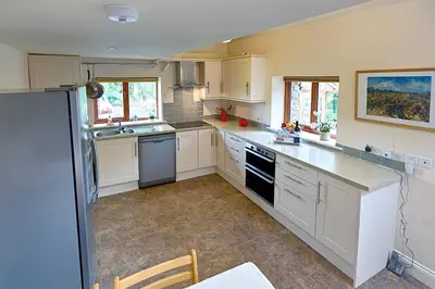 a large kitchen with white cabinets and appliances at North Lake District rural retreat in Penrith