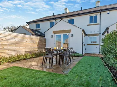 a patio with a table and chairs in front of a house at 3 Bed in Loweswater 94152 in Arlecdon