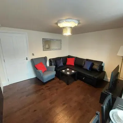 a living room with a couch and a chair at Kirkcudbright Holiday Apartments - Apartment A in Kirkcudbright