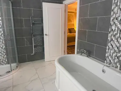 a bathroom with a bath tub and a shower at Kings Arms Hotel in Lockerbie