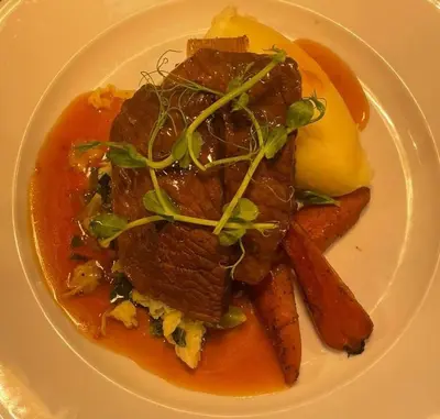 a white plate of food with meat and potatoes at Kings Arms Hotel in Lockerbie