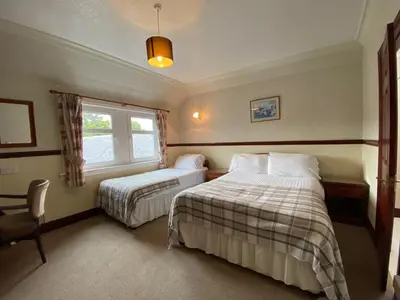 a bedroom with two beds and a window at Kings Arms Hotel in Lockerbie