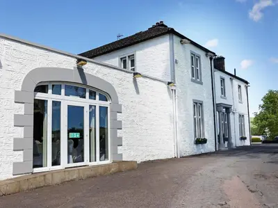 a white brick building with a large window at Dryfesdale Hotel - BW Signature Collection in Lockerbie