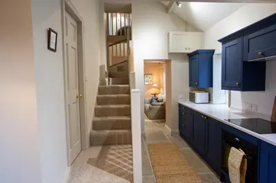 a kitchen with blue cabinets and a stairway at The Tower in Carlisle