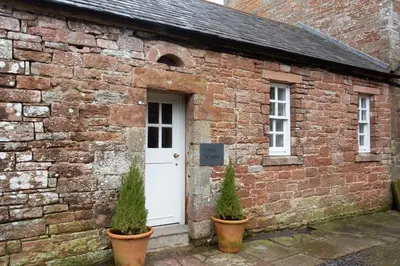 a brick building with two potted plants in front of it at The Tower in Carlisle