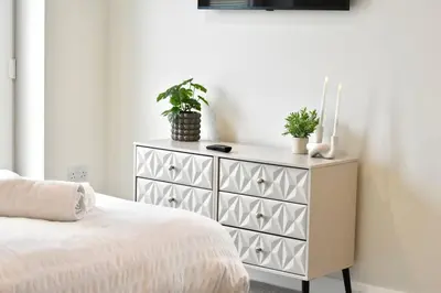 a bedroom with a dresser with two potted plants on it at *Penthouse Luxury Apartment 2min to City in Carlisle