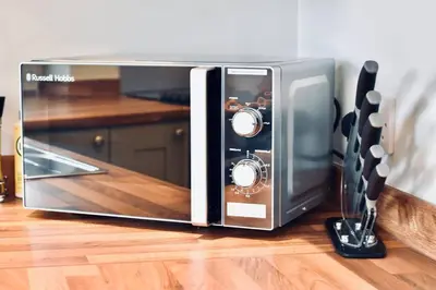 a microwave oven sitting on top of a kitchen floor at *Luxury Apartment 2min from City in Carlisle