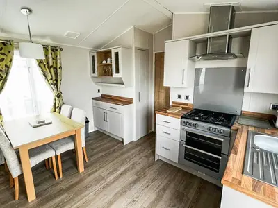 a kitchen with a table and a stove top oven at Beeches View in Mainsriddle