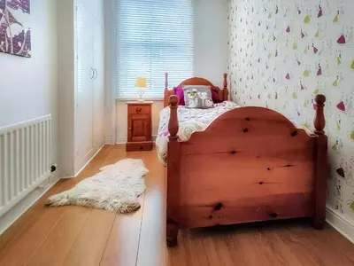 a bedroom with a wooden bed and a white rug at Little Hills in Keswick