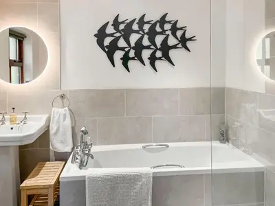 a bathroom with a bath tub and a sink at The Clachan Bothy in Drumpark