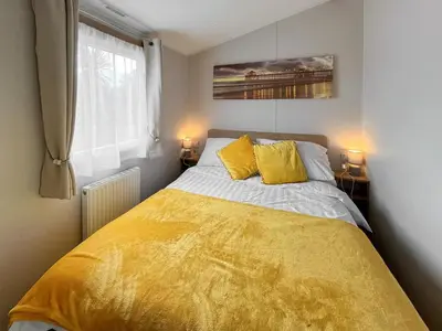 a bedroom with a yellow bed with two yellow pillows at Sandy Paws - Uk45511 in Mainsriddle