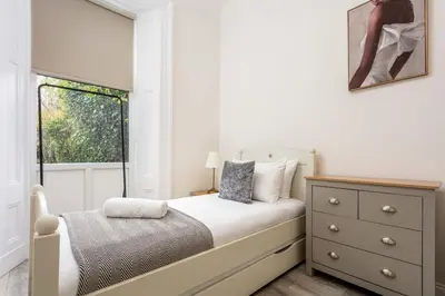 a small bedroom with a bed and a window at Cuthbert House in Prestwick
