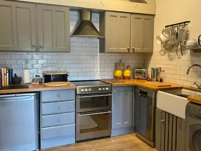 a kitchen with blue cabinets and a stove top oven at 1 Bed in Ullswater 94064 in Watermillock