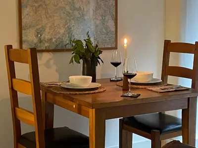 a wooden table with two glasses of wine and a vase at 1 Bed in Watermillock 94065 in Watermillock