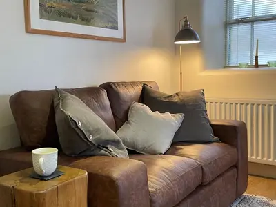 a brown couch with pillows on it in a living room at 1 Bed in Watermillock 94065 in Watermillock