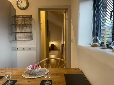 a dining room table with a clock on the wall at 1 Bed in Watermillock 94068 in Watermillock