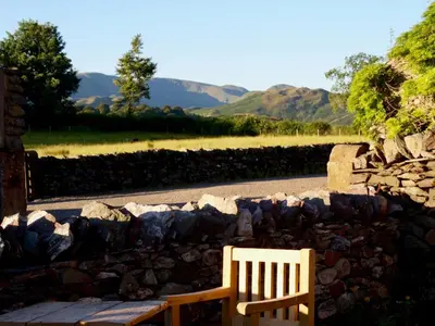 a wooden bench sitting next to a pile of rocks at 1 Bed in Watermillock 94068 in Watermillock