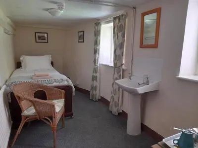 a small bedroom with a bed and a sink at Burnthwaite Farm B&B in Wasdale