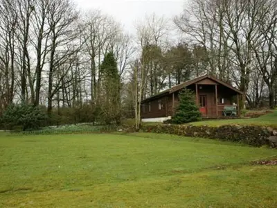 a small house in the middle of a green field at Kirkconnel Hall Hotel in Lockerbie