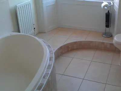 a bathroom with a tub and a tile floor at Kirkconnel Hall Hotel in Lockerbie