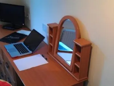 a wooden desk with a mirror and a laptop on it at Kirkconnel Hall Hotel in Lockerbie