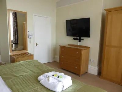 a bedroom with a bed and a flat screen tv at Bailey Ground Lodge in Seascale