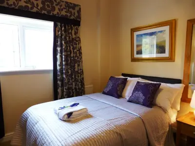 a bedroom with a bed with a suitcase on it at Bailey Ground Lodge in Seascale