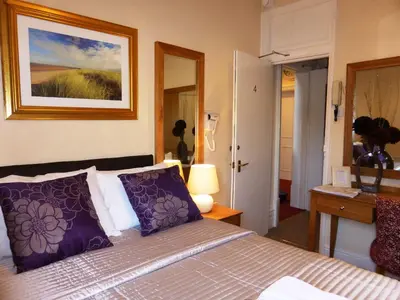 a bedroom with a bed with purple pillows at Bailey Ground Lodge in Seascale
