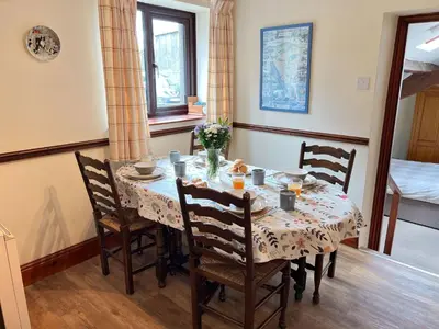 a dining room with a table with chairs and a table and chairsuggest at Bassenthwaite Farm Cottage, on a working farm in a tranquil setting in Bassenthwaite
