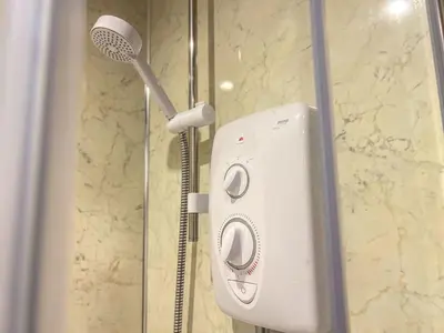 a shower with a shower head in a bathroom at Bassenthwaite Farm Cottage, on a working farm in a tranquil setting in Bassenthwaite