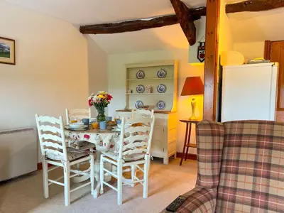a kitchen with a table and chairs and a refrigerator at Fell View Bassenthwaite, rural location on a working farm in the fells in Bassenthwaite