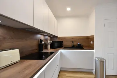 a kitchen with white cabinets and a counter top at Troon Portland Apt A in Troon