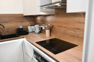 a kitchen with white cabinets and a counter top at Troon Portland Apt B in Troon
