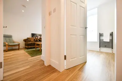 an open door in a living room with a couch at Troon Portland Apt B in Troon